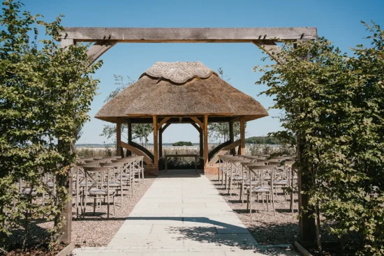 outdoor wedding ceremony by the thatched bower
