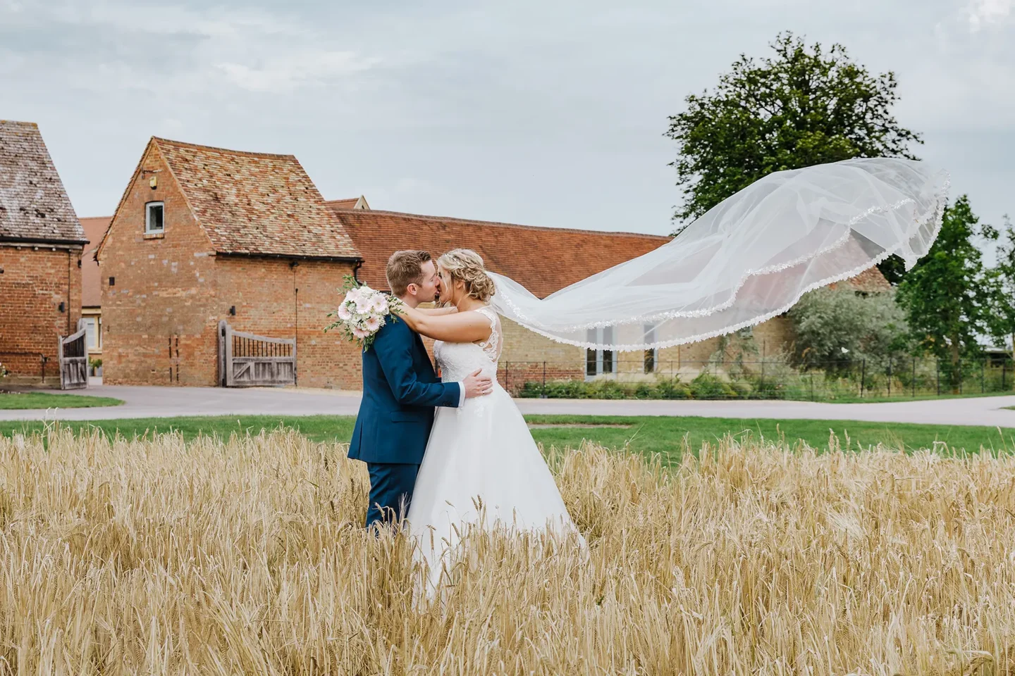 bride and groom in a field at bassmead manor barns