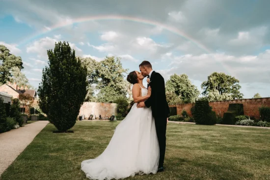 combermere abbey couple kissing under rainbow