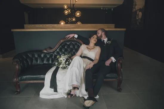 bride and groom relaxing on a sofa in the atrium