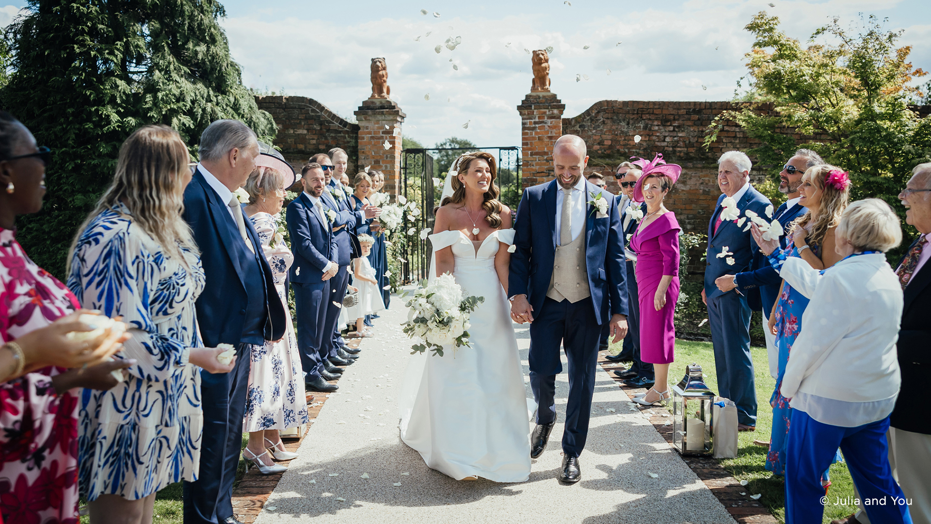 A bride and groom celebrate their confetti moment on their wedding day at Gaynes Park wedding venue in Essex