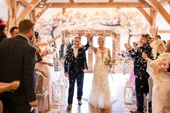 Newlyweds are showered in confetti following their wedding ceremony at Sandhole Oak Barn