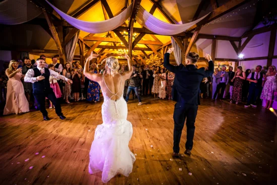 A bride and groom enjoy their first dance in the oak barn at Sandhole