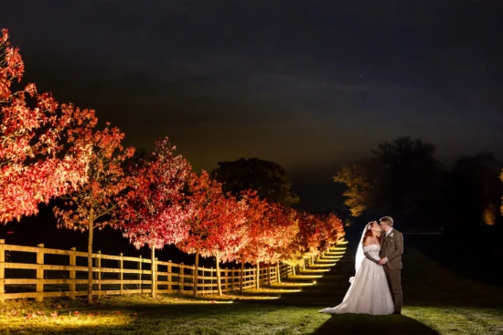 A couple embrace on the driveway at Sandhole Oak Barn in Cheshire